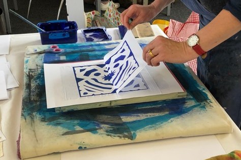 A maker demonstrates part of a screen printing process