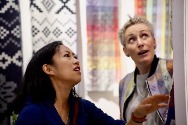 Maker Lisa Watson showing a customer some textiles at the Great Northern Contemporary Craft Fair
